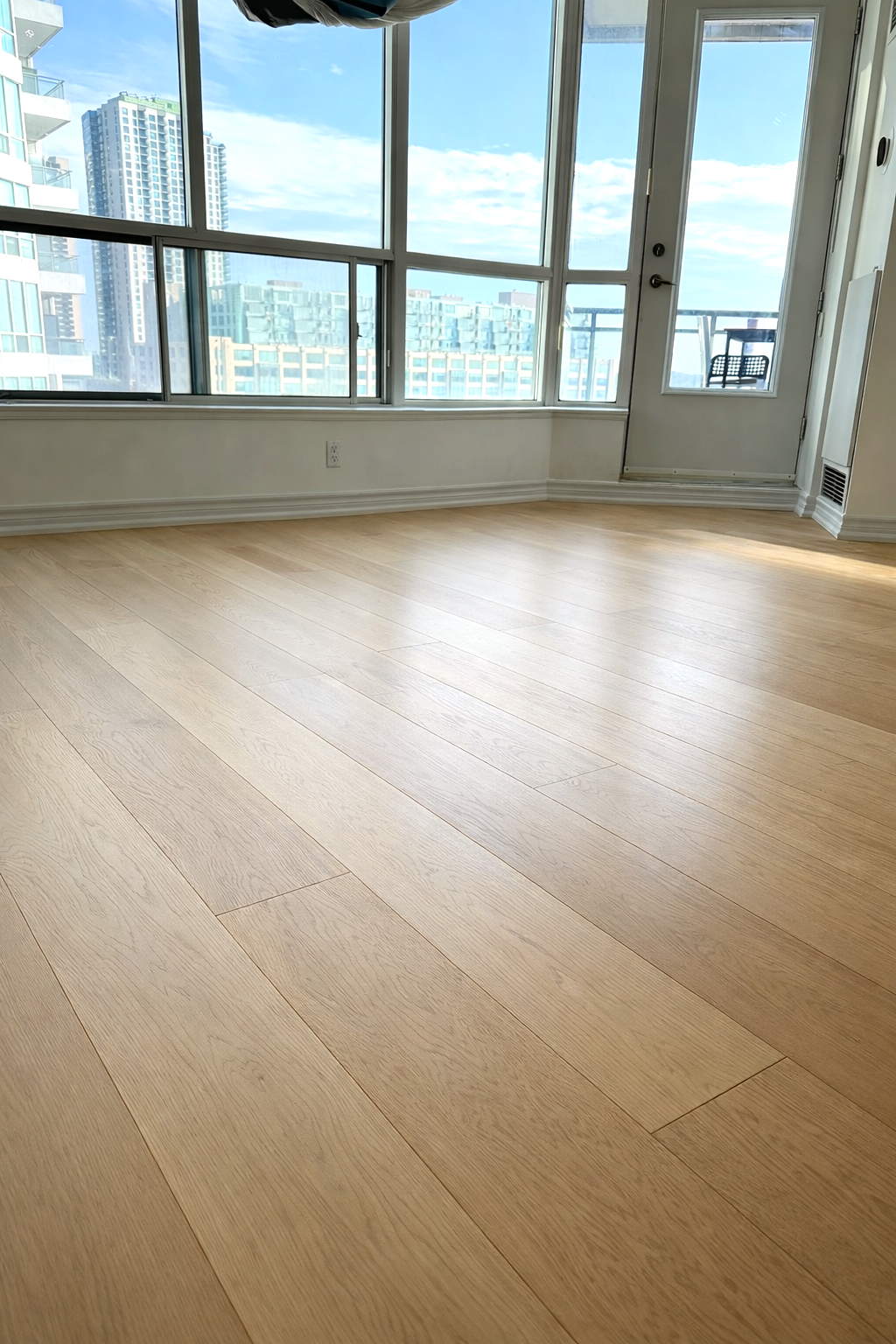 Professional hardwood floor installation in a living room, showcasing the rich color and grain of the oak wood